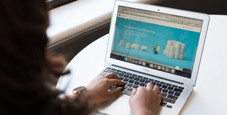 Close-up of hands typing on a laptop keyboard, representing the hands-on time small business owners spend managing a self-hosted WordPress website